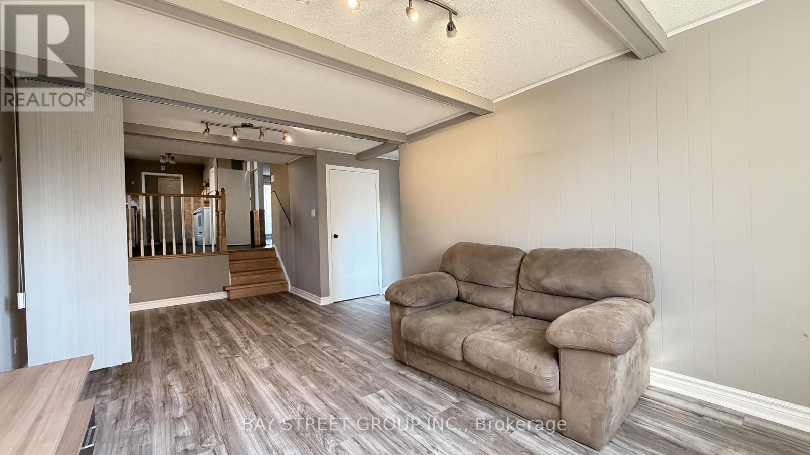A living room with a couch and a staircase in the background.