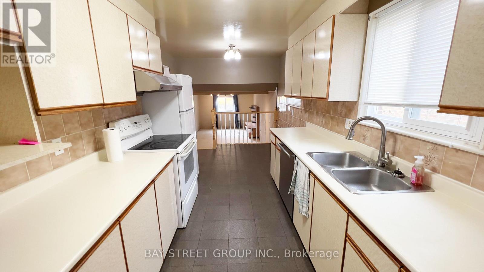 A kitchen with white appliances and beige cabinets.