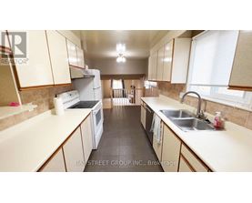 A kitchen with white appliances and beige cabinets.