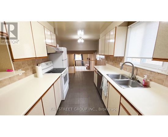 A kitchen with white appliances and beige cabinets.