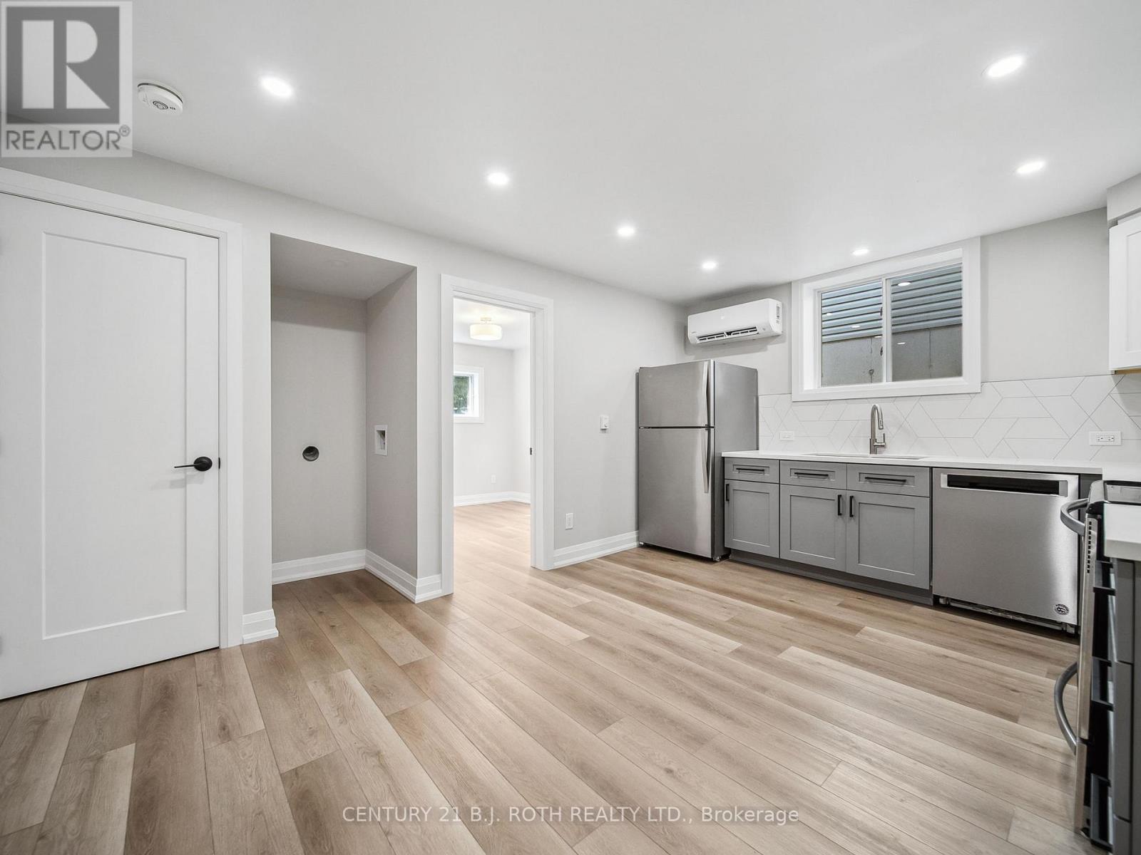 A kitchen with white cabinets and a wooden floor.