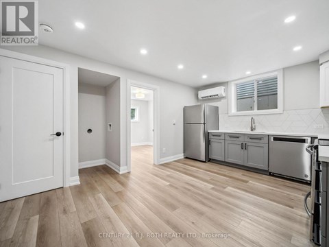 A kitchen with white cabinets and a wooden floor.