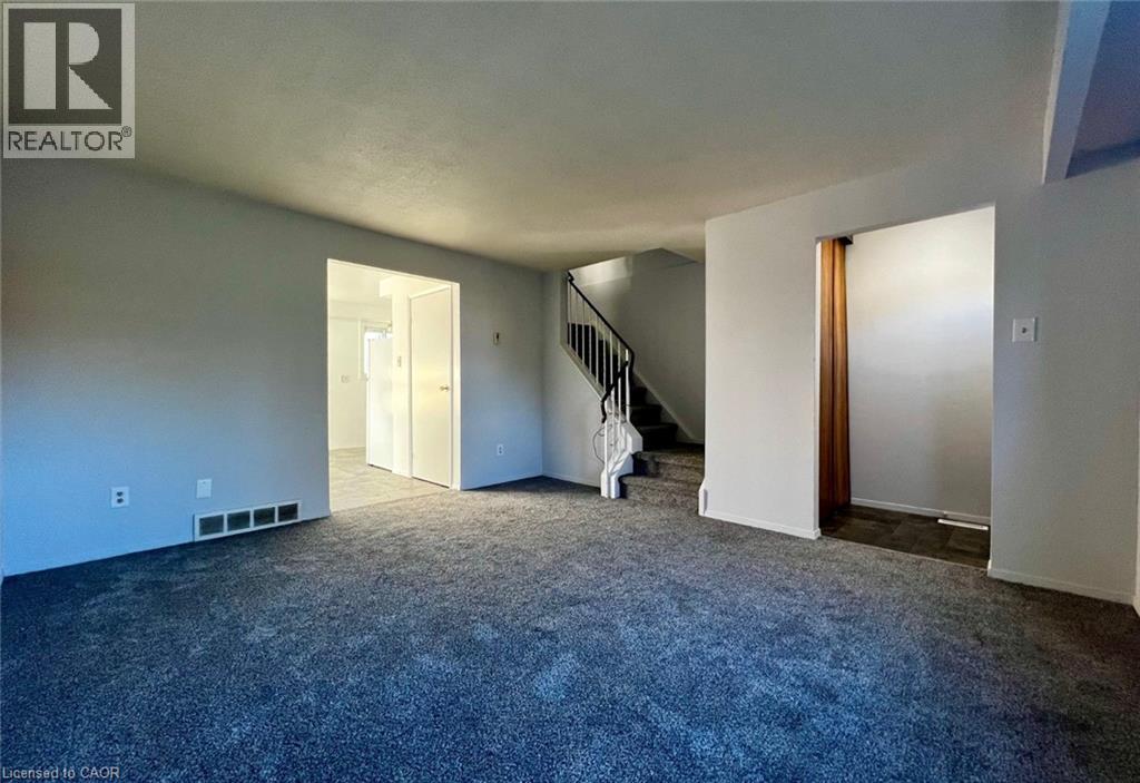 A spacious room with a staircase and two doors.