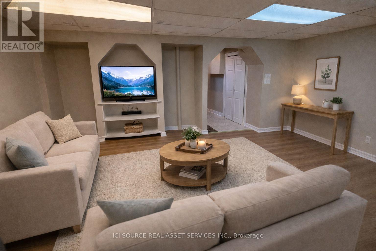 A living room with a couch, a coffee table, and a television.