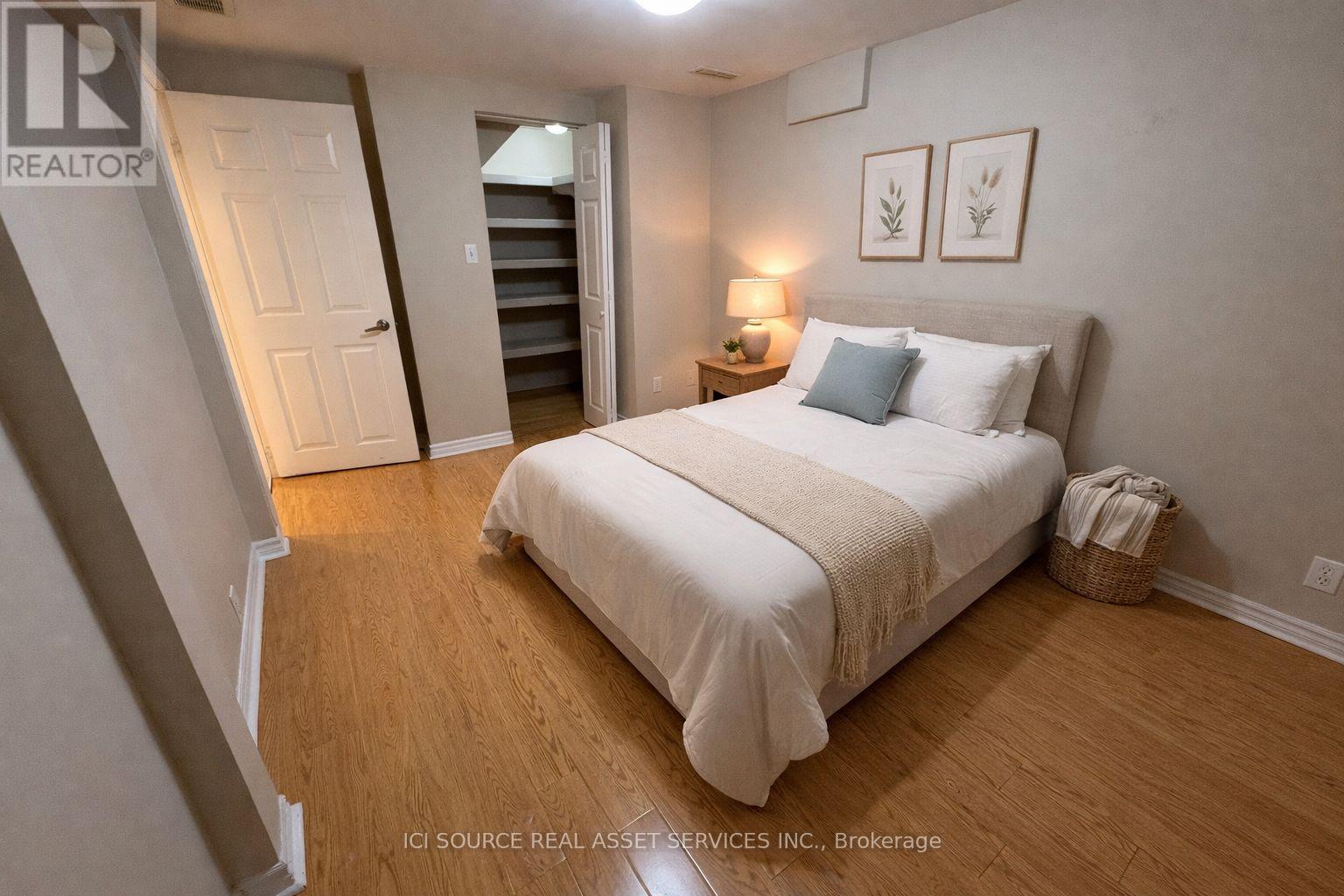 A bedroom with a bed, nightstand, and lamp.