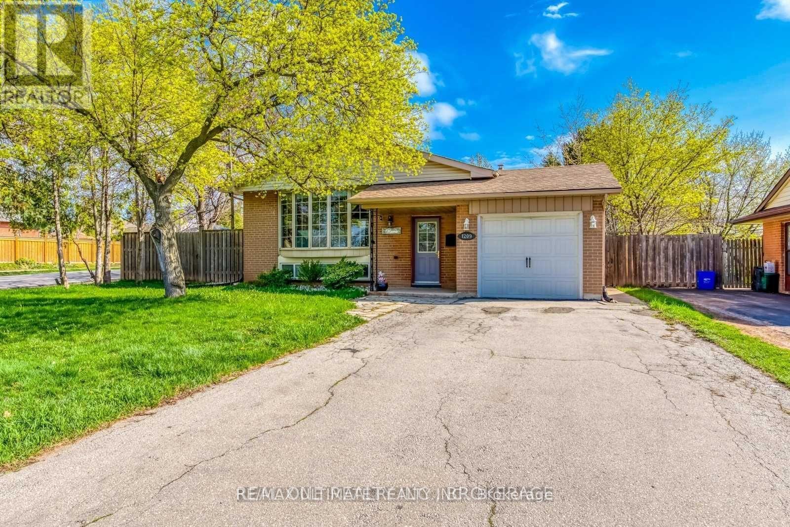 A house with a garage and a driveway in front of it.