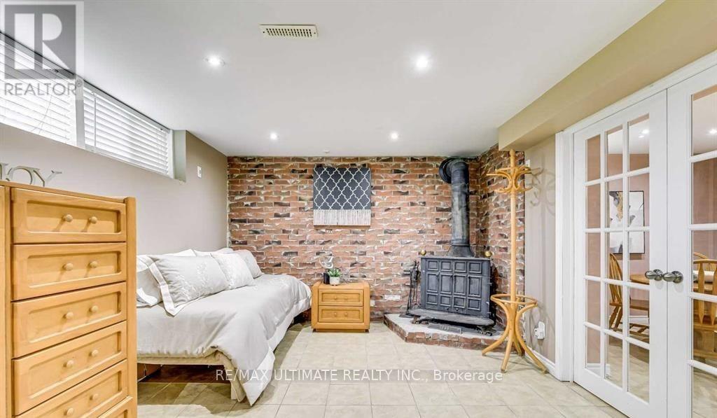 A bedroom with a brick wall and a wood stove.
