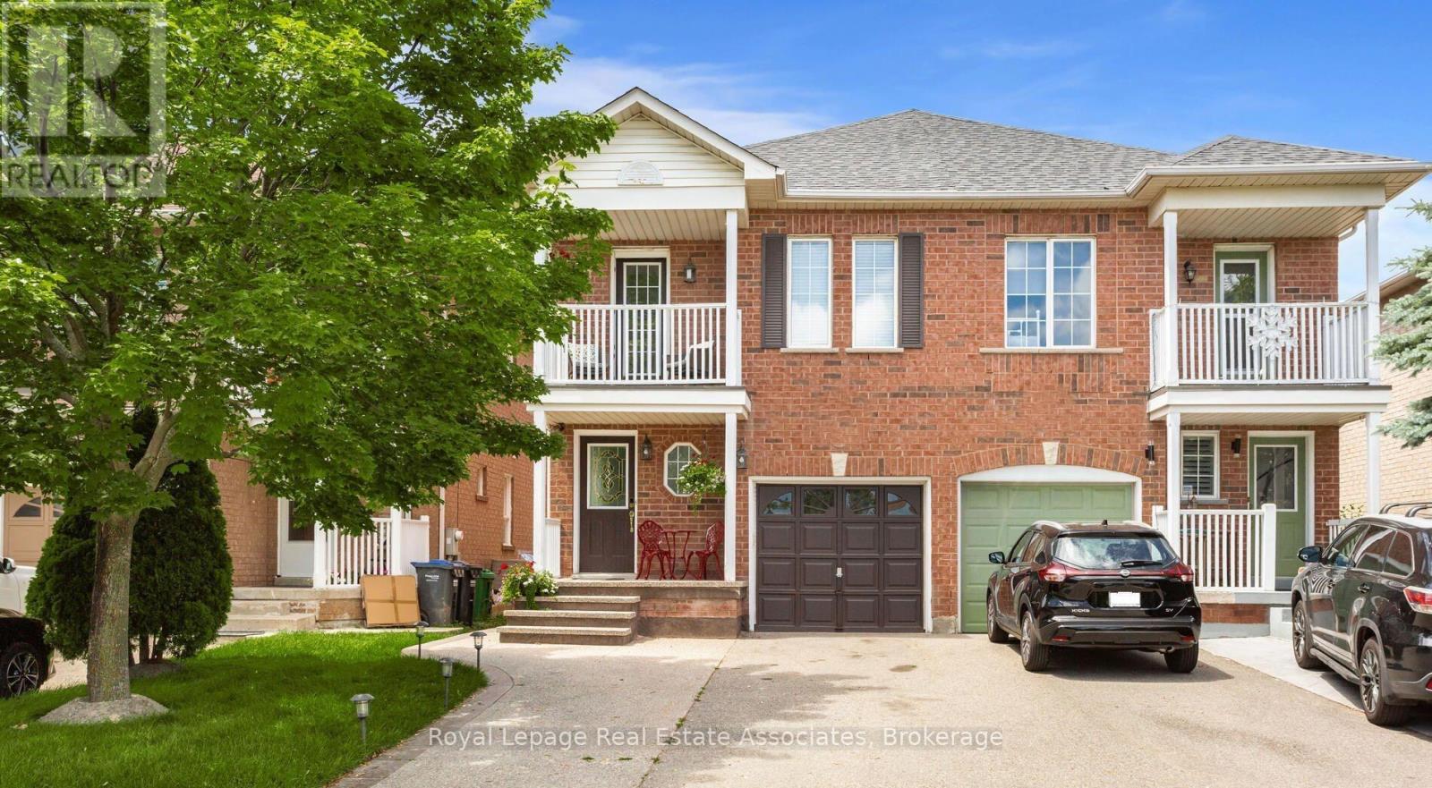 A two-story house with a red brick exterior and a white trim.