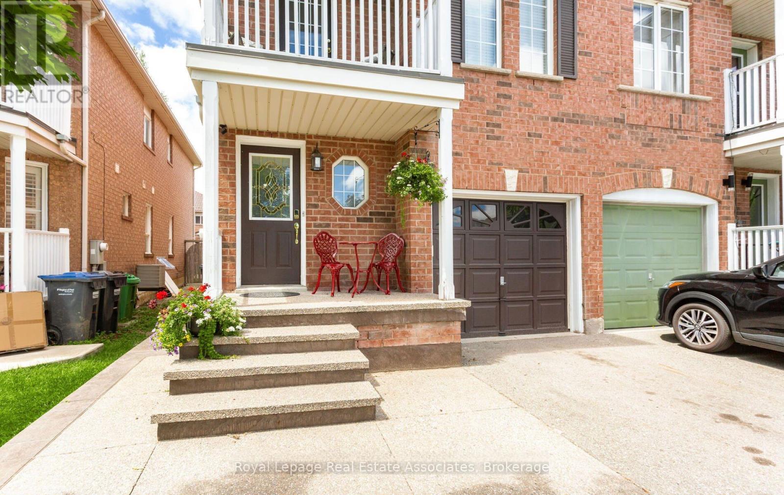 A house with a red brick facade and a white porch.