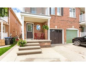 A house with a red brick facade and a white porch.