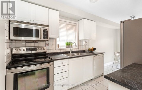 A kitchen with a stove, microwave, and oven.