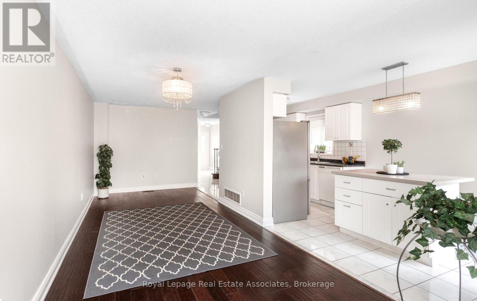 A well-lit, modern kitchen and dining area with a patterned rug on the floor.