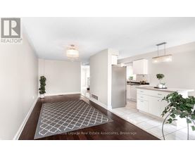 A well-lit, modern kitchen and dining area with a patterned rug on the floor.