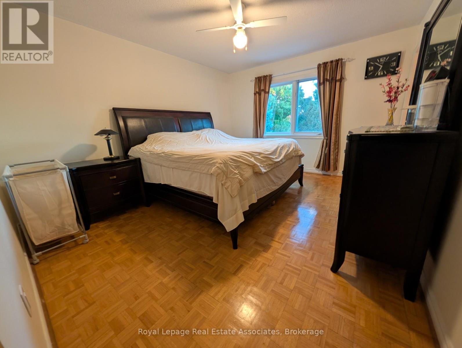 A bedroom with a bed, dresser, and mirror.