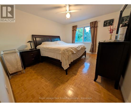 A bedroom with a bed, dresser, and mirror.
