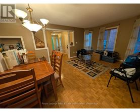 A dining room with a wooden table and chairs.