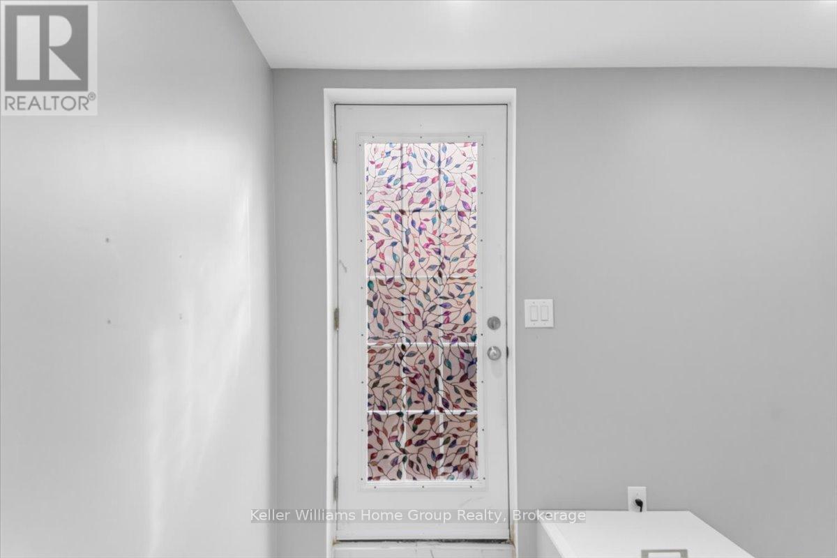 A white door with a glass window covered in pink and white flowers.