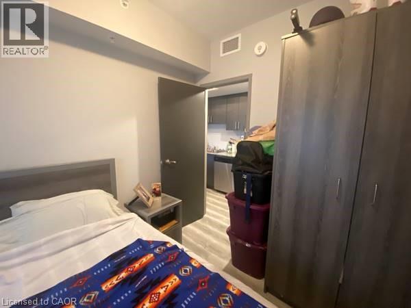 A bedroom with a bed, nightstand, and a wardrobe.