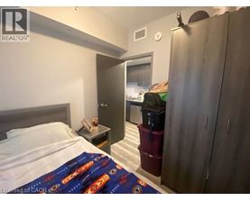A bedroom with a bed, nightstand, and a wardrobe.