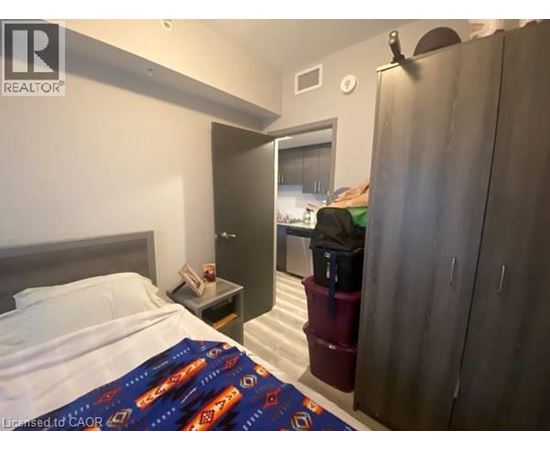 A bedroom with a bed, nightstand, and a wardrobe.