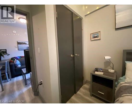 A bedroom with a bed, nightstand, and a wardrobe.