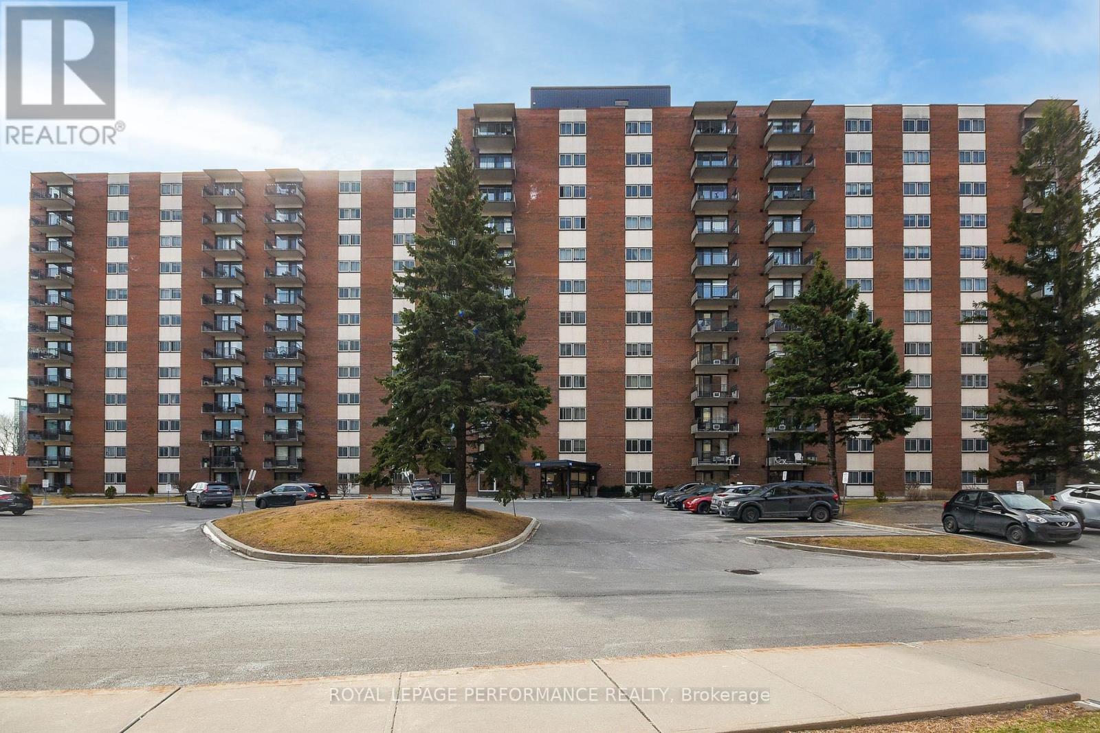 A large brick building with a parking lot in front.