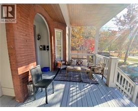 A wooden deck with a black chair and a cushioned bench.