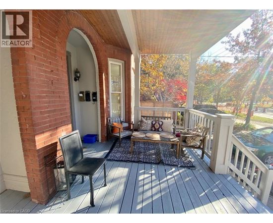 A wooden deck with a black chair and a cushioned bench.