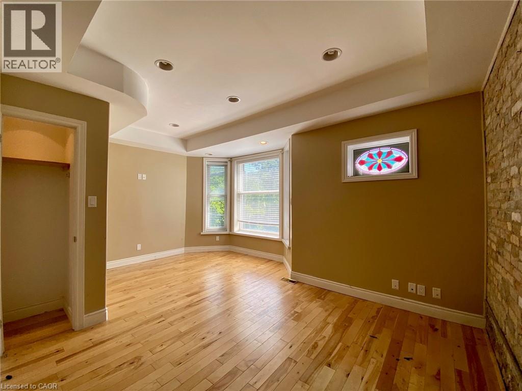 A room with wooden floors and a window with blinds.