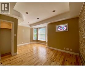 A room with wooden floors and a window with blinds.