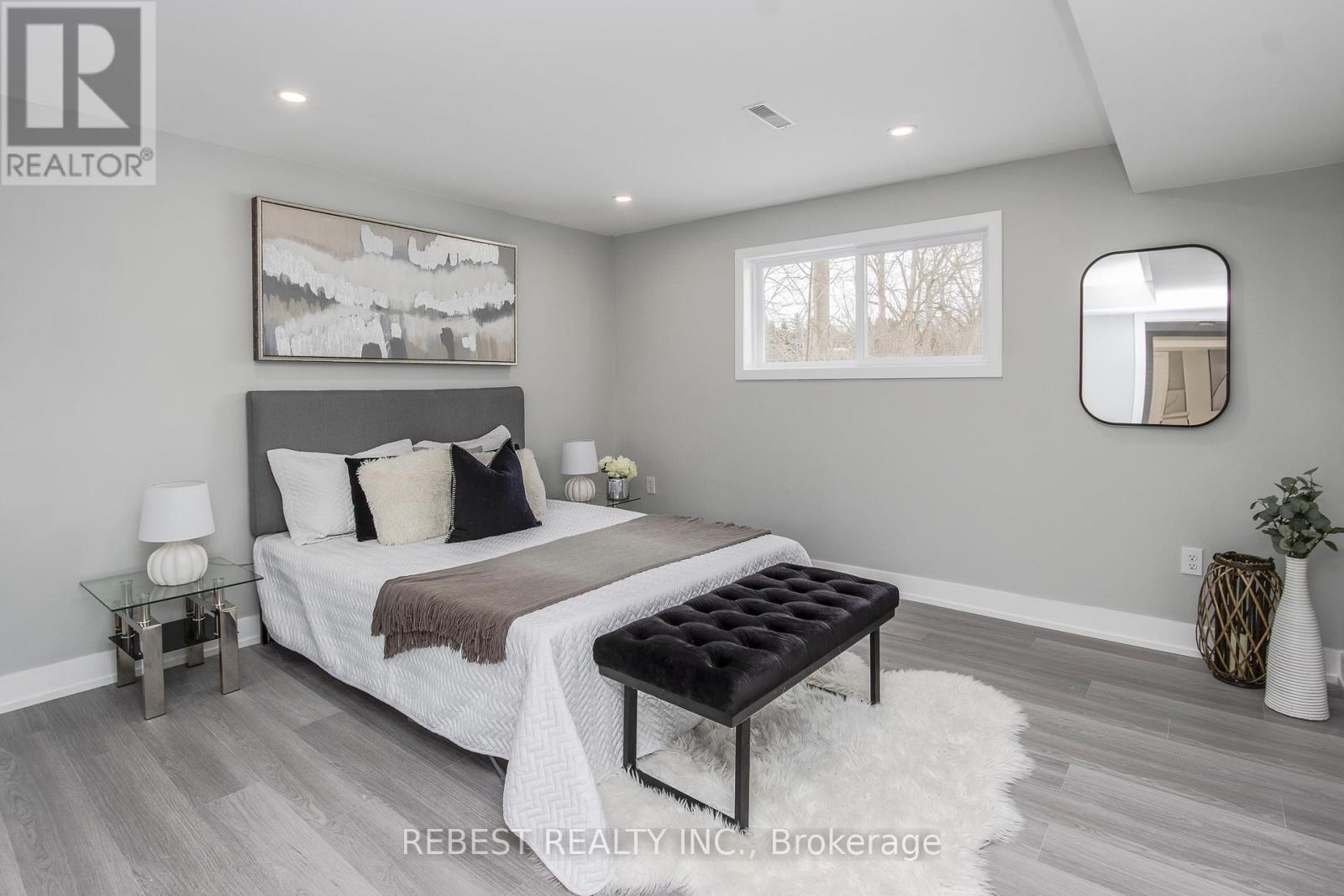 A bedroom with a large bed and a mirror on the wall.