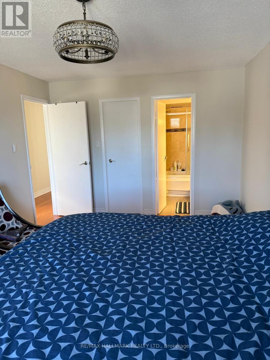A bedroom with a bed covered in a blue patterned sheet.