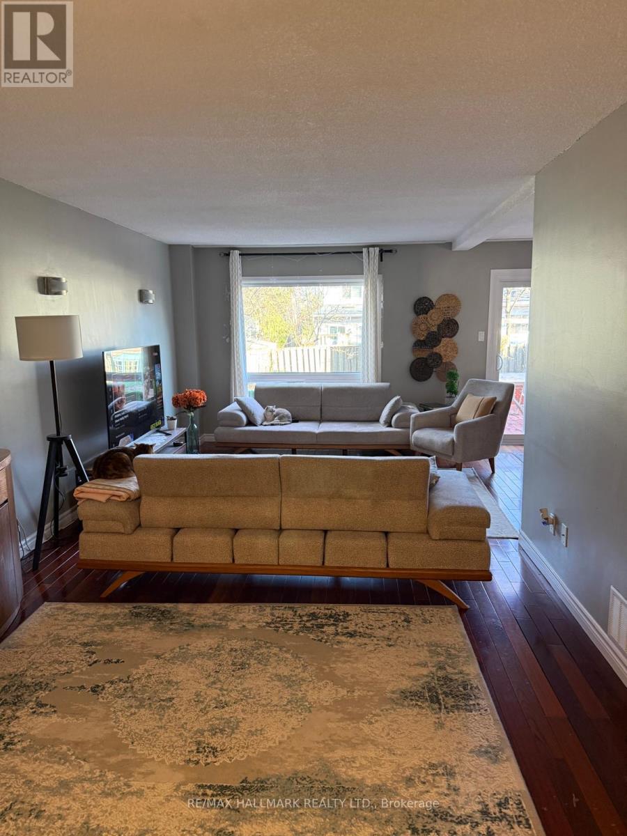 A living room with a couch, a chair, a television, and a rug.