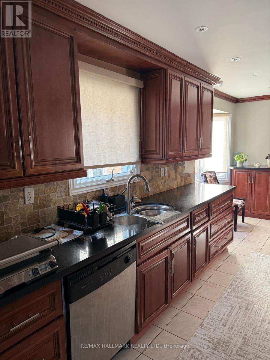 A kitchen with dark wood cabinets and black countertops.