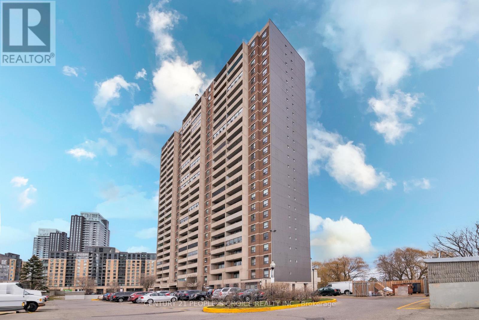A tall building with a parking lot in front of it.