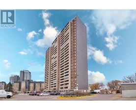 A tall building with a parking lot in front of it.