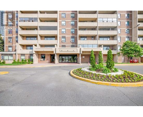 A large apartment building with a landscaped courtyard in front.