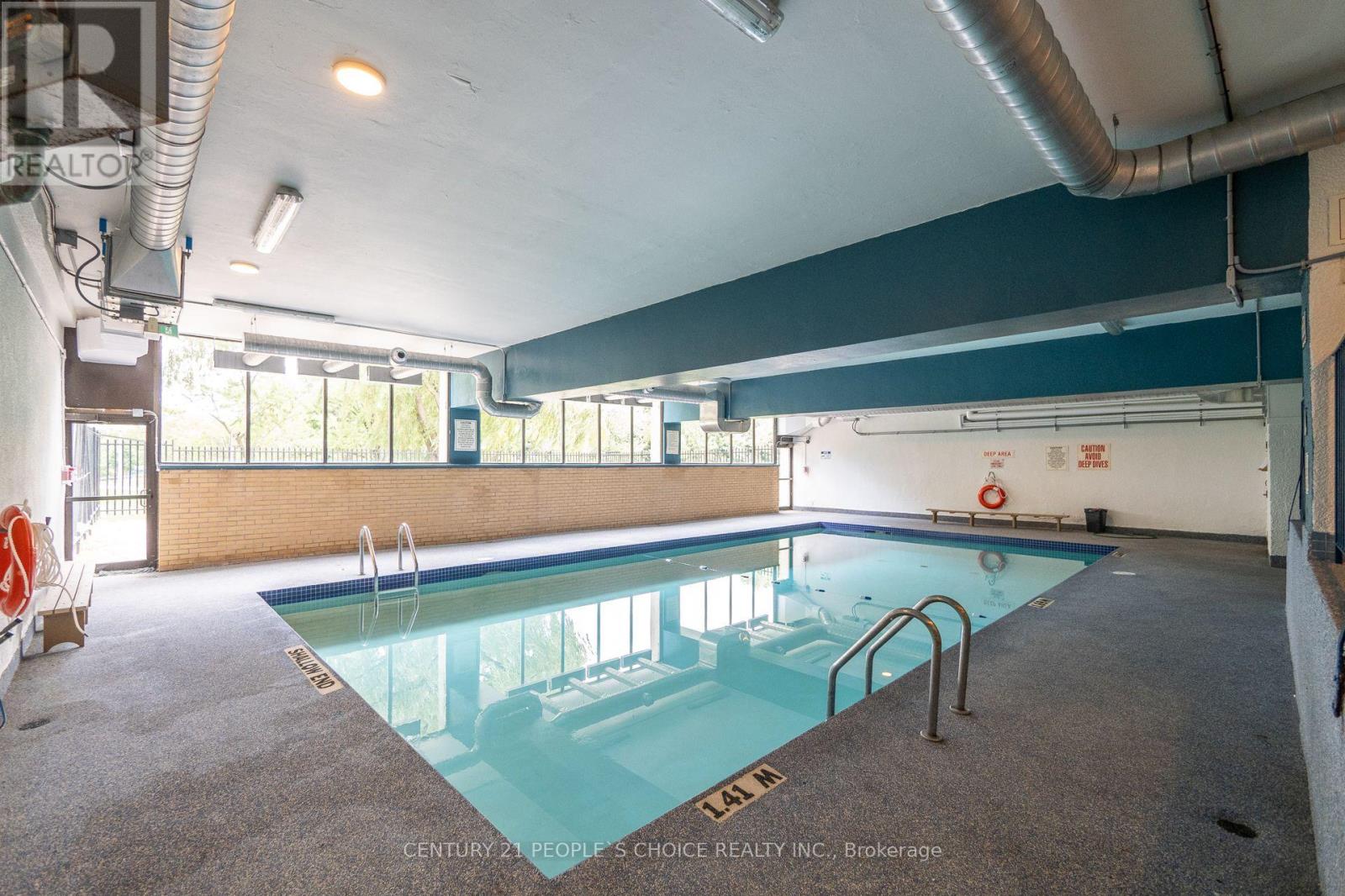 A large indoor swimming pool with a glass bottom.