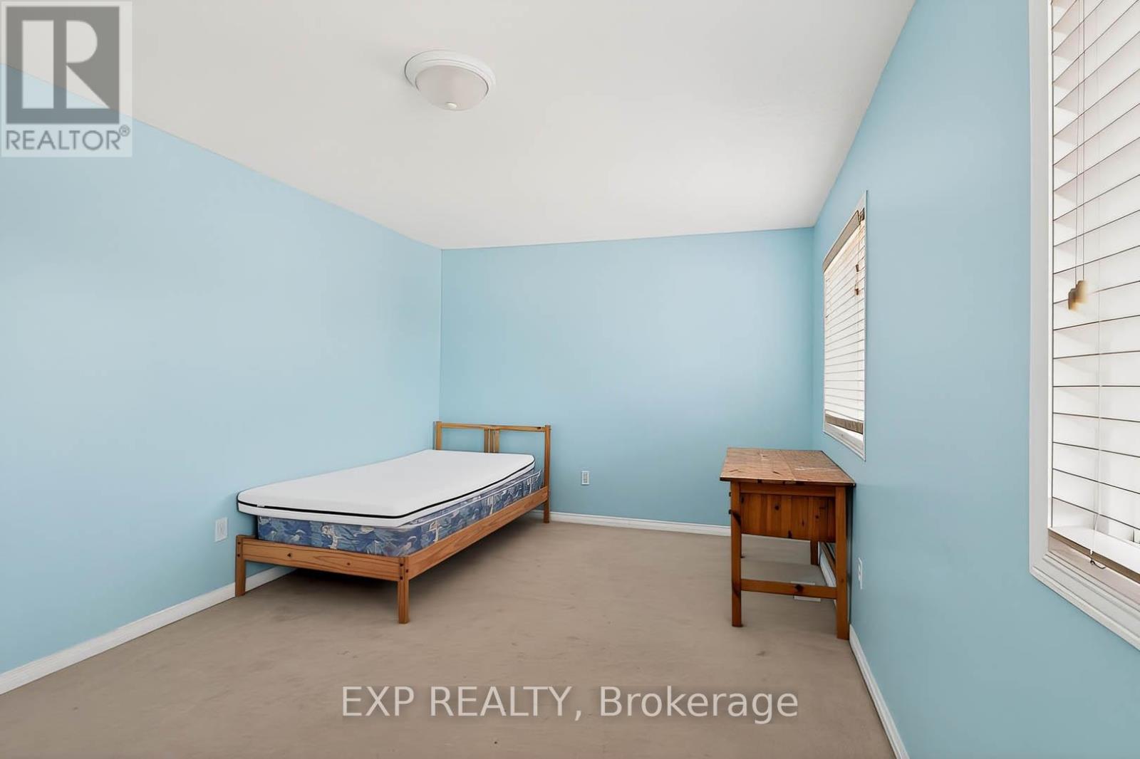 A bedroom with a bed and a desk.