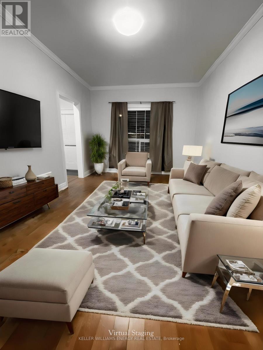 A living room with a grey rug and a white couch.