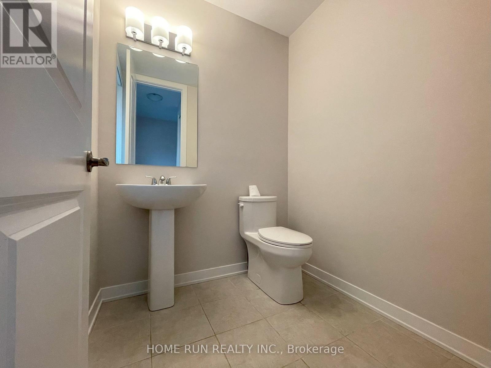 A bathroom with a sink, toilet and mirror.