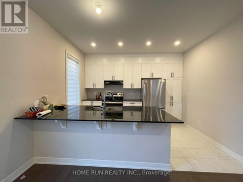 A kitchen with white cabinets and a black countertop.
