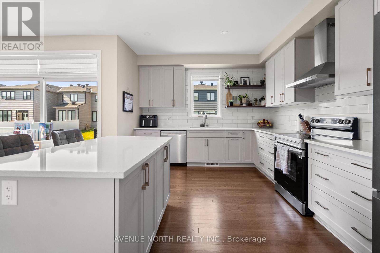 A modern kitchen with white cabinets and a large island.