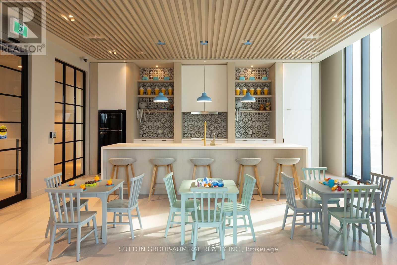 A modern dining room with a bar area and chairs around it.