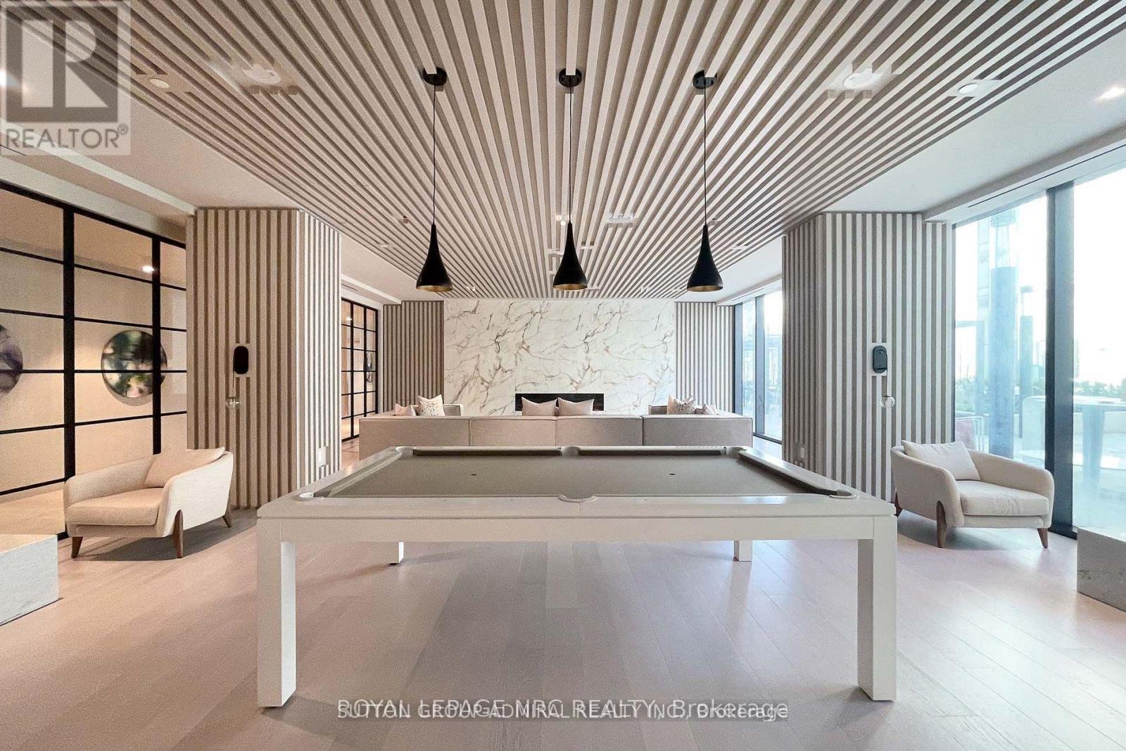 A modern living room with a pool table and striped walls.