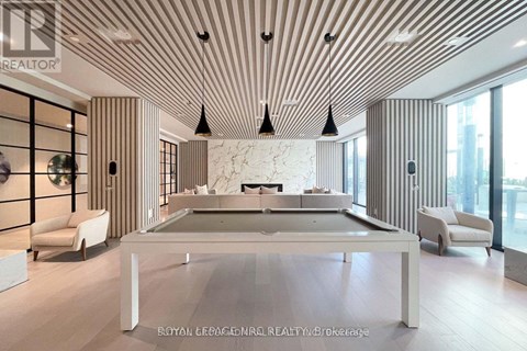 A modern living room with a pool table and striped walls.