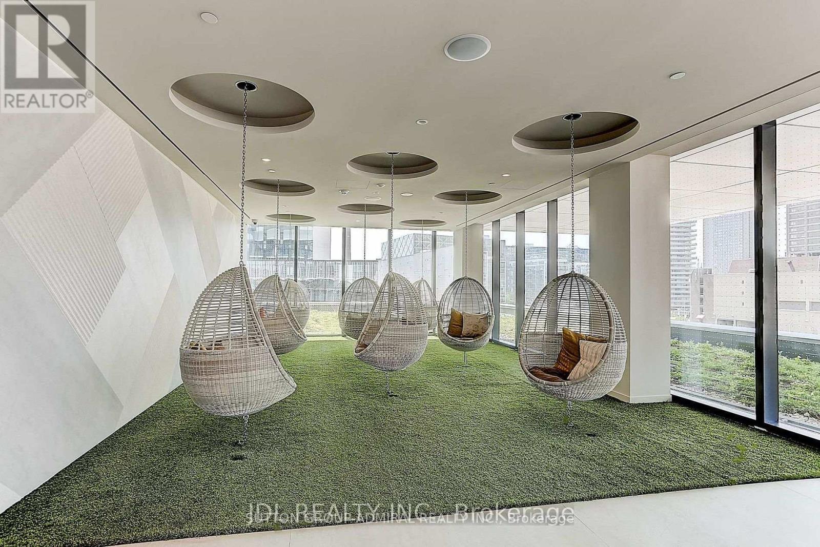 A modern office space with hanging chairs and a view of the city.