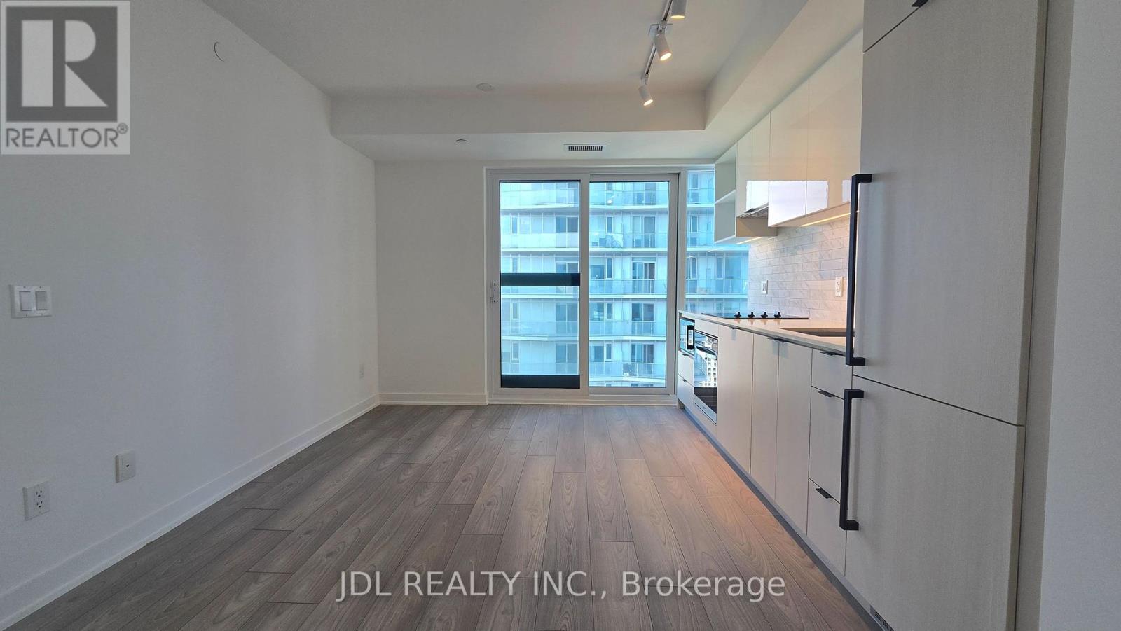 A brokerage listing image of a room with wooden floors and white walls.