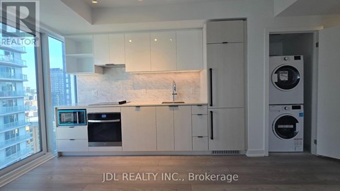 A modern kitchen with white cabinets and appliances.