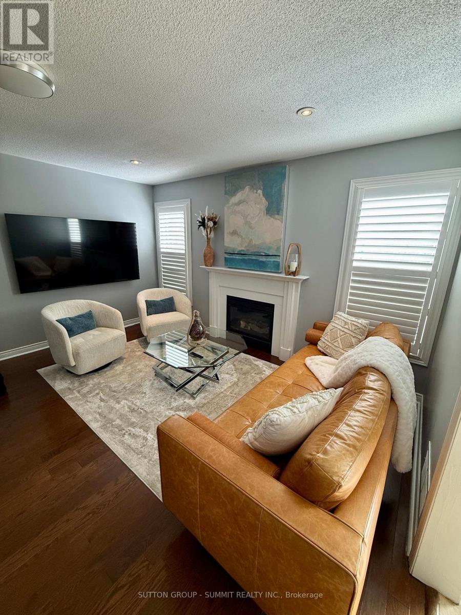 A living room with a brown leather couch and a flat screen TV mounted on the wall.